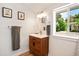 Modern bathroom with wood vanity, updated fixtures, and a window at 4090 Pelican Shores Cir, Englewood, FL 34223