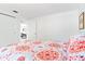 Bright bedroom with a patterned comforter and access to other rooms at 4090 Pelican Shores Cir, Englewood, FL 34223