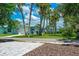 House with paved driveway and tropical landscaping at 4090 Pelican Shores Cir, Englewood, FL 34223