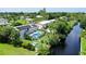 Aerial view showcasing a canal-front house with a pool and solar panels at 6 Cove Ln, Englewood, FL 34223