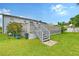 Landscaped backyard with wooden stairs leading to a deck at 6 Cove Ln, Englewood, FL 34223