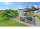 Landscaped backyard with patio furniture and umbrella at 6 Cove Ln, Englewood, FL 34223