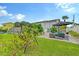 Landscaped backyard with patio furniture and umbrella at 6 Cove Ln, Englewood, FL 34223
