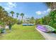 Backyard with kayaks and paddle boats, lush landscaping, and a grill at 6 Cove Ln, Englewood, FL 34223