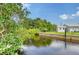 Serene canal-front view with lush greenery and a glimpse of a shed at 6 Cove Ln, Englewood, FL 34223