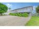House exterior showcasing light gray color, elevated deck, and gravel driveway at 6 Cove Ln, Englewood, FL 34223