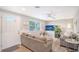 Bright living room with gray sofas, large TV and entryway at 6 Cove Ln, Englewood, FL 34223