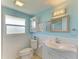 Bathroom with light blue walls, white vanity, and shower at 703 Portia N St, Nokomis, FL 34275