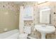 Clean bathroom with pedestal sink, tub/shower combo, and nautical wallpaper at 18069 Ohara Dr, Port Charlotte, FL 33948