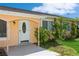 Quaint light orange home with white door and lush landscaping at 18069 Ohara Dr, Port Charlotte, FL 33948