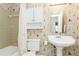 Clean bathroom with pedestal sink, tub, and nautical wallpaper at 18069 Ohara Dr, Port Charlotte, FL 33948