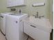 Convenient laundry room with washer, dryer, and utility sink at 5221 Laurel Oak Ct, North Port, FL 34287