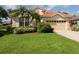 Tan house with tile roof, palm trees, and manicured lawn at 5221 Laurel Oak Ct, North Port, FL 34287