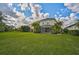 Large backyard with lush green grass and tropical landscaping at 12196 Alachua Ln, Venice, FL 34293