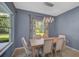 Bright dining room featuring a large wooden table and modern light fixture at 12196 Alachua Ln, Venice, FL 34293