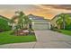 Two-story house with a green exterior, landscaping, and a two-car garage at 12196 Alachua Ln, Venice, FL 34293
