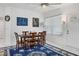 Bright dining room with wooden table, six chairs, and blue rug at 200 Gardens Edge Dr # 213, Venice, FL 34285