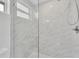 Modern shower with marble tile and glass enclosure at 200 Gardens Edge Dr # 213, Venice, FL 34285