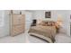 Spacious bedroom with a large bed, dresser, and chair at 200 Gardens Edge Dr # 213, Venice, FL 34285