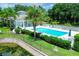 Community pool with adjacent building and lush landscaping at 200 Gardens Edge Dr # 213, Venice, FL 34285