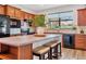 Kitchen island with granite countertop, wood cabinets and black appliances at 19185 Mangieri St, Venice, FL 34293