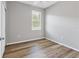 Empty bedroom with wood-look floors and window with shutters at 19185 Mangieri St, Venice, FL 34293