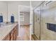 Bathroom with granite vanity, walk-in shower and wood-look flooring at 19185 Mangieri St, Venice, FL 34293