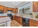 Kitchen with granite countertops, wood cabinets, and black appliances at 19185 Mangieri St, Venice, FL 34293