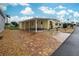 Yellow single-wide home with carport and landscaped yard at 628 Cervina Dr, Venice, FL 34285