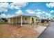 Yellow single-wide home with carport and landscaped yard at 628 Cervina Dr, Venice, FL 34285