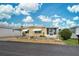Yellow single-wide home with carport and landscaped yard at 628 Cervina Dr, Venice, FL 34285