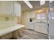 Bright kitchen featuring white cabinets and wood-look flooring at 628 Cervina Dr, Venice, FL 34285