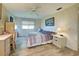 Comfortable bedroom features wood-look flooring, ceiling fan, and built-in shelving at 628 Cervina Dr, Venice, FL 34285