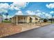 Yellow single-wide home with carport and landscaped yard at 628 Cervina Dr, Venice, FL 34285