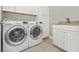 Laundry room with LG washer and dryer and white cabinetry at 13091 Borrego St, Venice, FL 34293