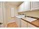 Bright laundry room with washer, dryer, cabinets, and built-in shelving at 6360 Watercrest Way # 203, Lakewood Ranch, FL 34202