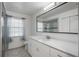 Modern bathroom with white vanity, large mirror, and a walk-in shower at 5896 Buchanan Rd, Venice, FL 34293