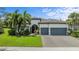 Two-story house with a three-car garage and lush landscaping at 7801 Grande Shores Dr, Sarasota, FL 34240