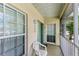 Inviting front porch with teal door and white chair, great for relaxing outdoors at 872 Saranac Lake Dr # 202, Venice, FL 34292