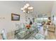 Bright dining room with glass table and living room view at 872 Saranac Lake Dr # 202, Venice, FL 34292