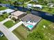 Aerial view of canal front property with pool and nearby homes at 15060 Aquarius Cir, Port Charlotte, FL 33981