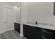 Modern bathroom with dark vanity, marble countertops, and patterned floor tiles at 15060 Aquarius Cir, Port Charlotte, FL 33981