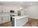 Modern kitchen with white cabinets, quartz countertops, and stainless steel appliances at 2443 Penguin Ln, North Port, FL 34286