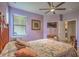 Lavender bedroom with queen bed, ceiling fan, and TV at 18837 Lanuvio St, Venice, FL 34293