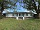 White house with light teal shutters, double front doors, and a large tree in the front yard at 2961 Valencia Rd, Venice, FL 34293