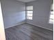 Well-lit bedroom with grey wood-look flooring and neutral walls at 2961 Valencia Rd, Venice, FL 34293