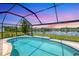 Relaxing screened-in pool and lanai overlooking a tranquil lake at sunset at 4762 Escalante Dr, North Port, FL 34287