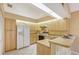 Galley kitchen with light wood cabinets and stainless steel appliances at 338 Pembroke Dr # 208, Venice, FL 34293