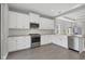 Modern kitchen with white cabinets, stainless steel appliances, and a farmhouse sink at 12760 Brookgreen St, Venice, FL 34293