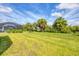 Spacious backyard with lush grass, palm trees, and screened enclosure at 12760 Brookgreen St, Venice, FL 34293